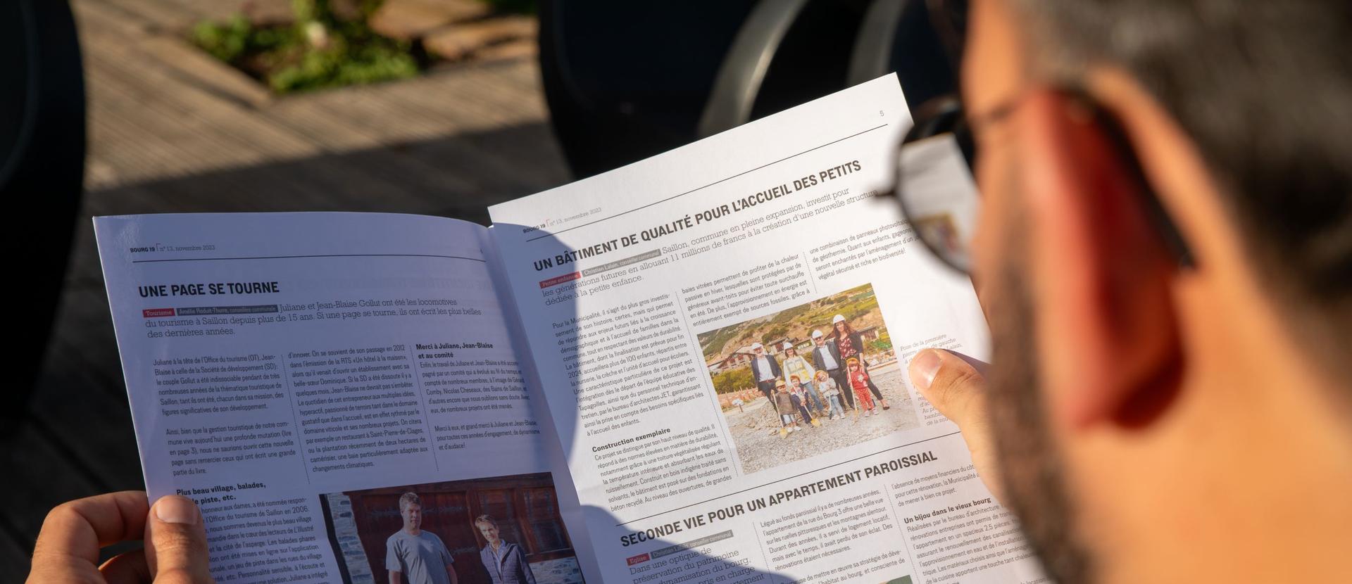 Une personne lit le journal communal
