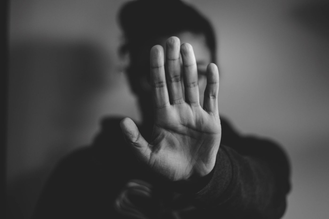 Schwarzweiss-Foto mit Frau die Hand abwehrend vor sich hält