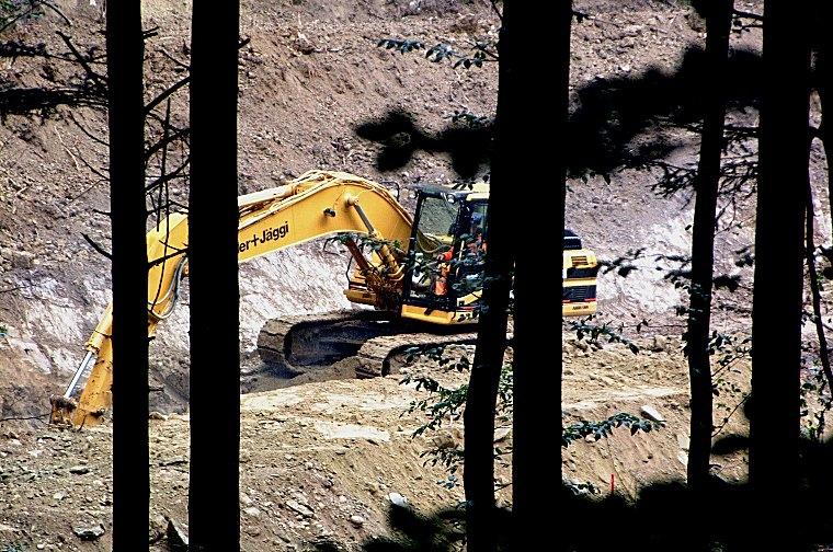 Der Bagger gräbt sich bei strömendem Regen ins Erdreich des abgeholzten Drachtenlochs.