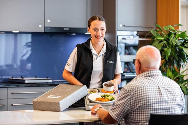 Frau serviert Essen