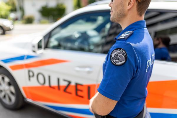 Symbolbild - Polizist steht neben Streifenwagen