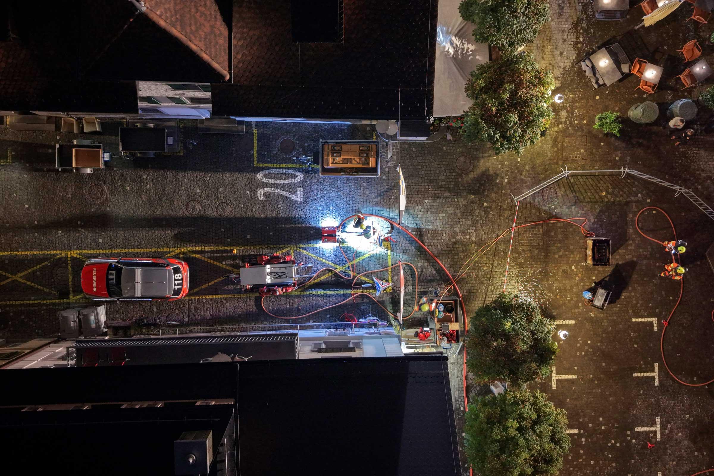 Mit der Motorspritze fördern die Feuerwehrleute Wasser aus dem geöffneten Dorfbach.