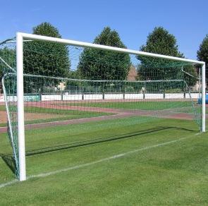 Grüner Fussballplatz mit Tor im Vordergrund