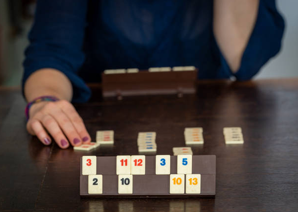 Une femme joue au jeu de société Rummikub