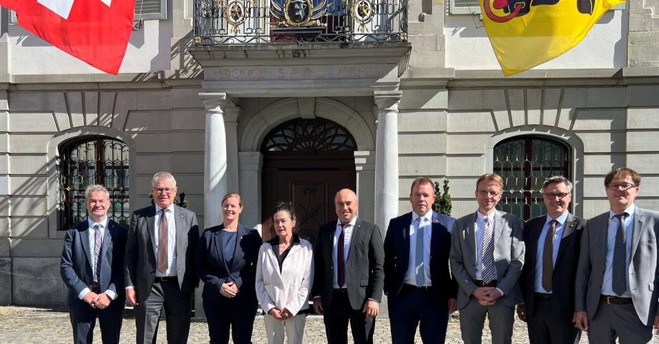 Landammann Daniel Furrer (Bildmitte) und der Gesamtregierungsrat mit Barbla Graf, der abtretenden Geschäftsleiterin der Patenschaft für Berggemeinden, beim Gruppenbild vor dem Rathaus.