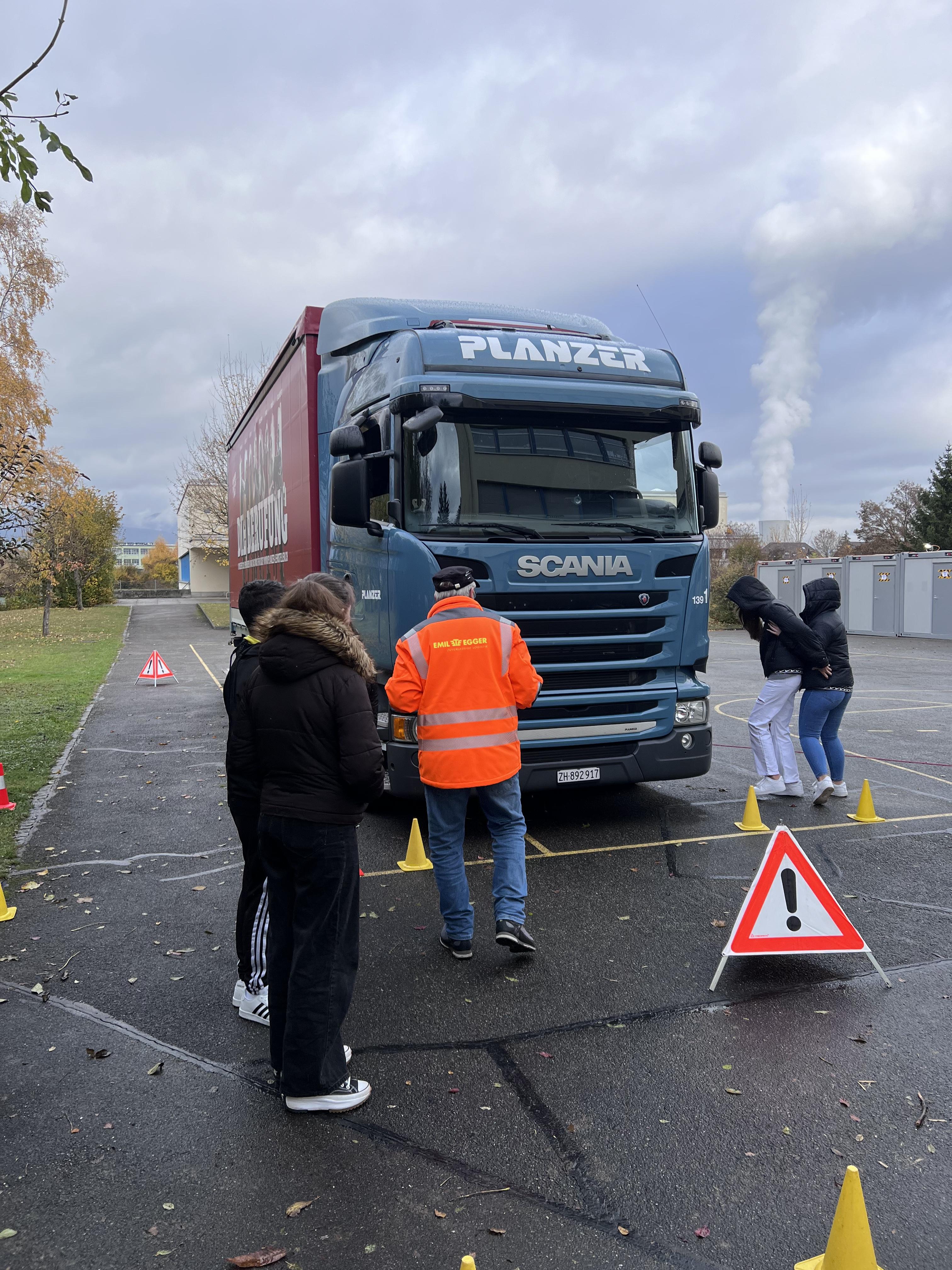 Wir durften in den Lastwagen vorne einsteigen. 4 Leute setzten sich in den Lastwagen und schauten sich die Ansicht an, die der Chauffeur hat. Die anderen warteten draussen und hörten dem Mann zu.