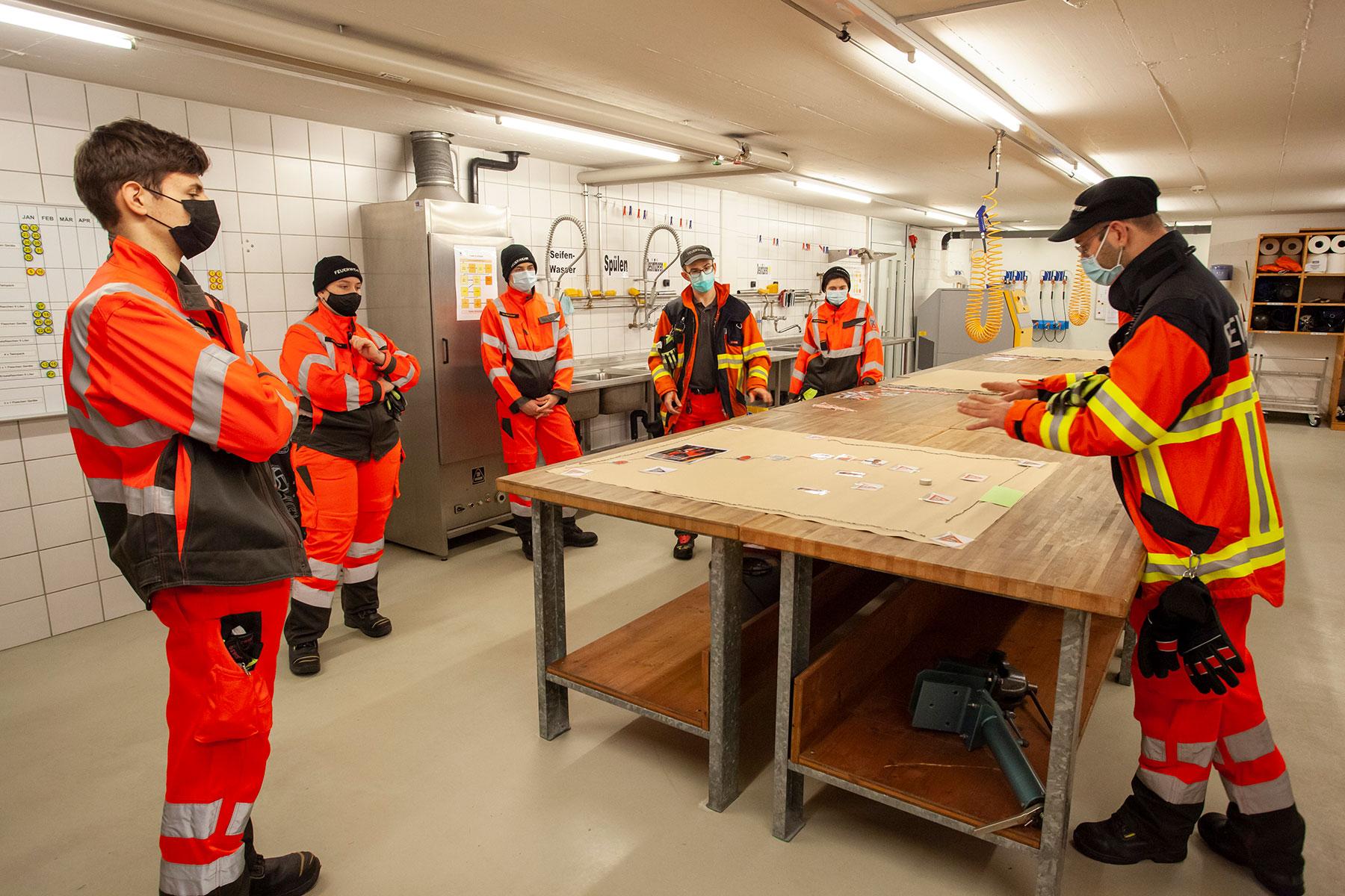 Die neu in die Feuerwehr Eingeteilten nehmen an einer Lektion über die Schadenplatzorganisation teil.