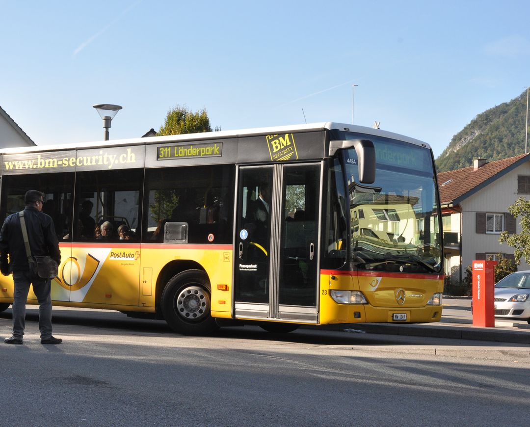Ein Postauto fährt vom Bahnhof Stans los.