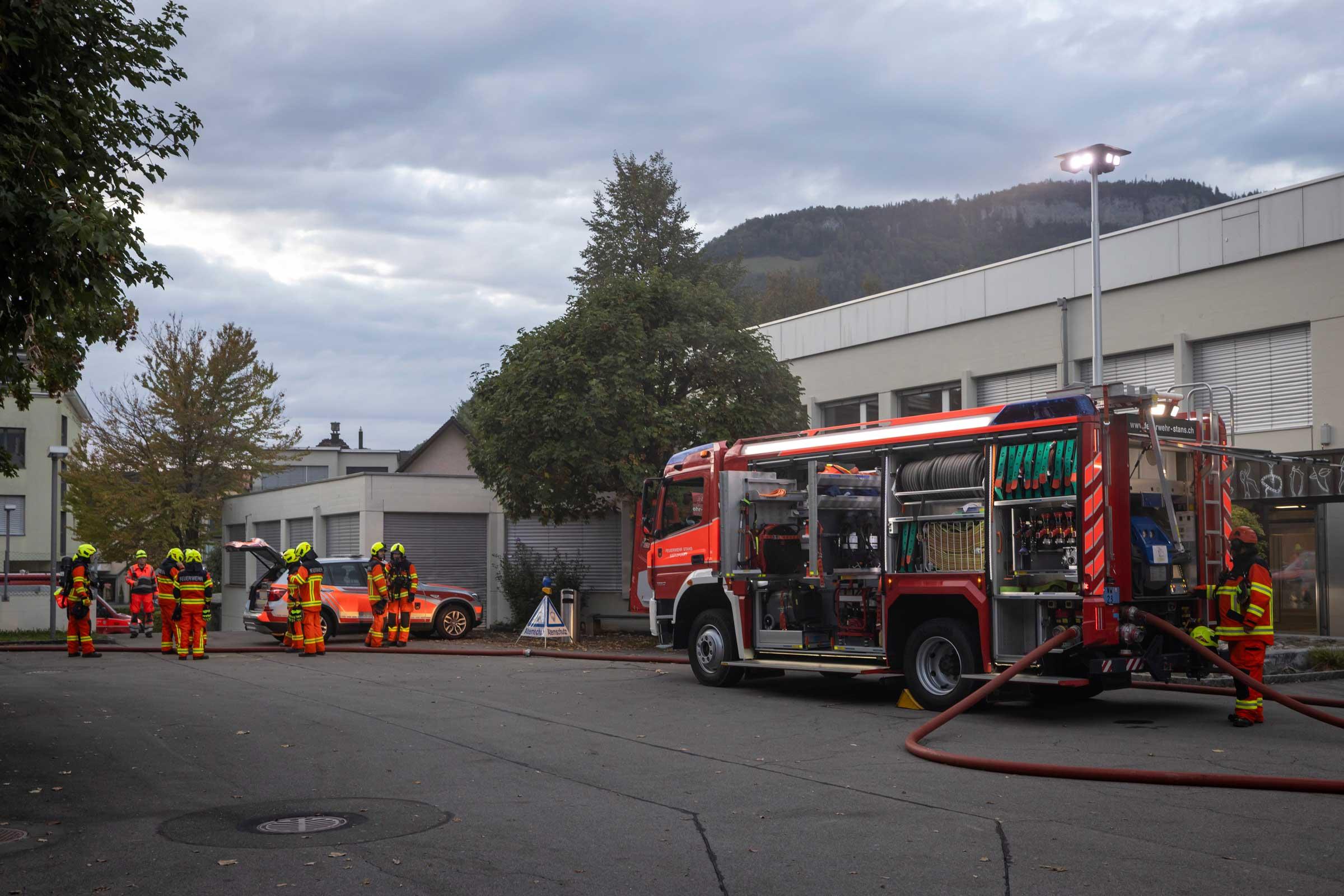 Der Schulhausplatz füllt sich mit Fahrzeugen und Feuerwehrleuten.
