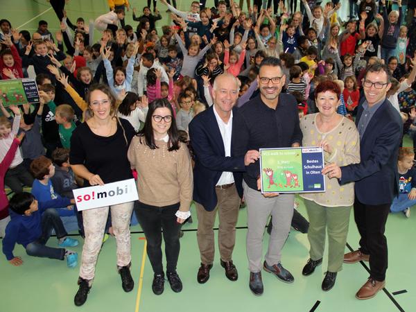 Schulleitungen posieren mit Urkunde