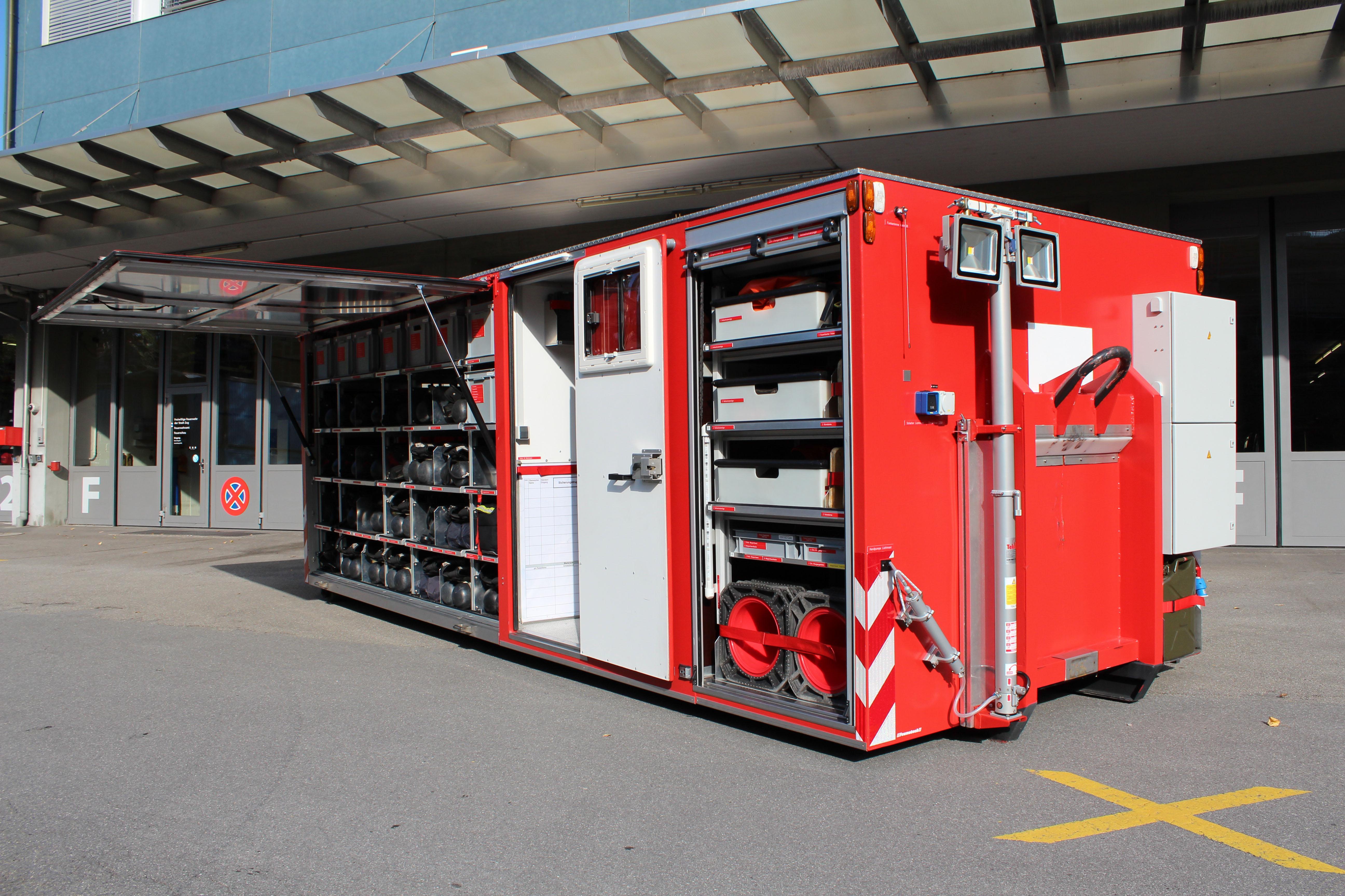 Feumotech, 2013
Vorne: Generator, Scheinwerfer, Kabelrollen, Heizofen, CSA schwer, Absperrmaterial
Innenraum: AS Geräte 1 Flaschen, AS Geräte 2 Flaschen, Reserve Flaschen, Getränke, Funk Polycom/Analog, CSA leicht, Nomex Unterwäsche, Filtermasken, Ersatzwäsche, Dekodusche, Absperrmaterial