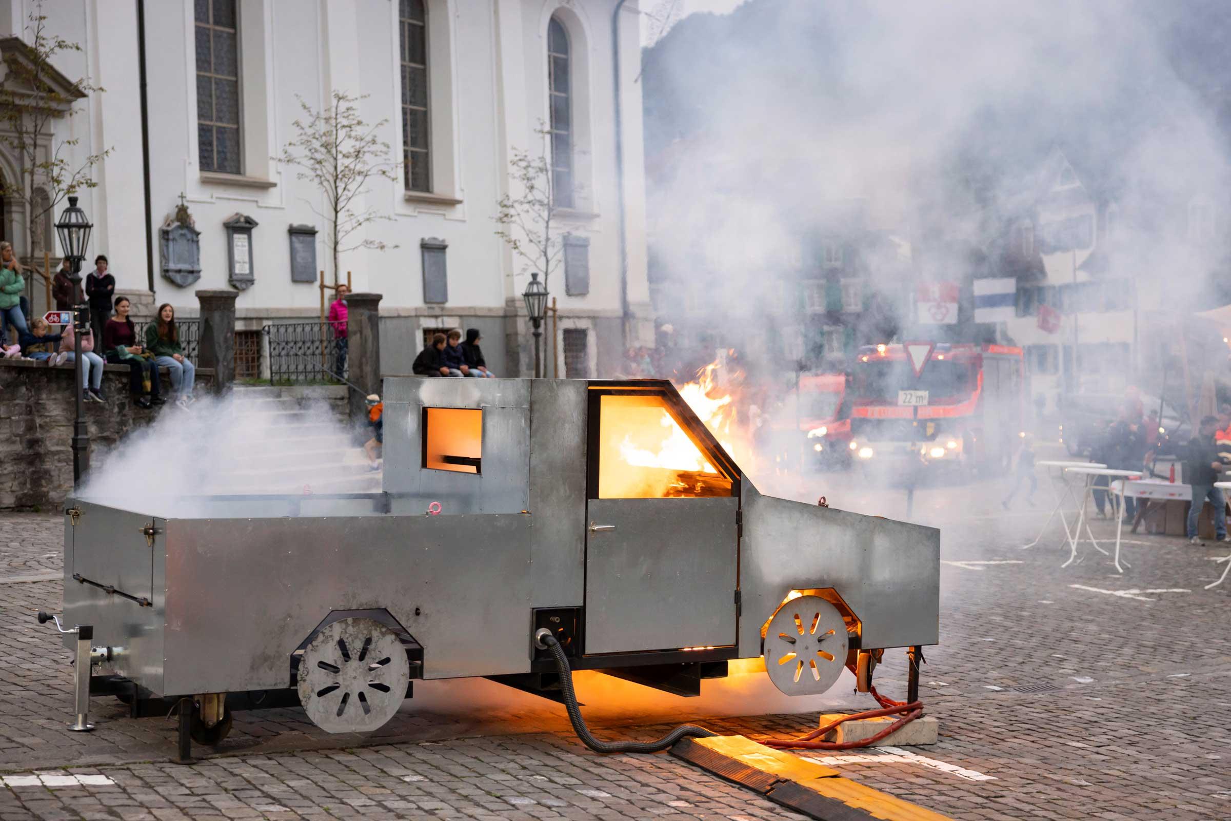 Als Übungsobjekt für die Feuerwehrleute brennt eine Autoattrappe.