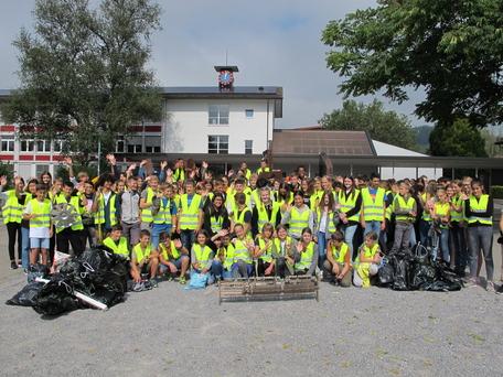 Die Abfall sammelnden Schülerinnen und Schüler mit dem gefundenen Klavierteil im Vordergrund.