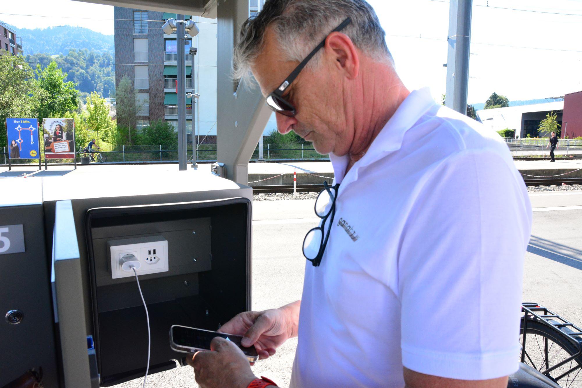 Ein Mann lädt sein Handy an der Solarladestation auf