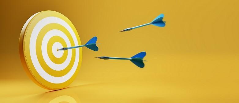 Bild mit einer Dartscheibe und drei fliegenden Pfeilen