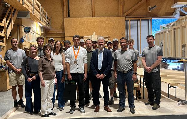Gratulanten und Arbeitskollegen beim Gruppenbild: (vorne, von links) Julia Brand, Yvonne Slon-go (Vorsteherin Amt für Berufsbildung), Karin Reinhard (Mutter), Silbermedaillengewinner Micha-el Tresch, Heinz Tresch (Vater), Regierungsrat Georg Simmen und Bernhard Schuler (Holzbau Bissig AG). 