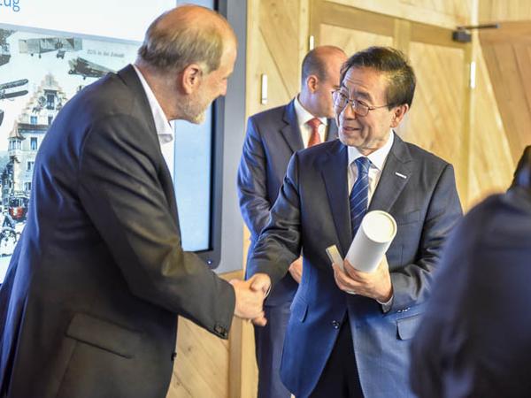 Der Bürgermeister von Seoul bekommt von Dolfi Müller eine Flasche Kirsch und ein Victorinox-Messer überreicht