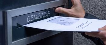 Ein Stimmcouvert wird in den Briefkasten der Gemeinde eingeworfen.