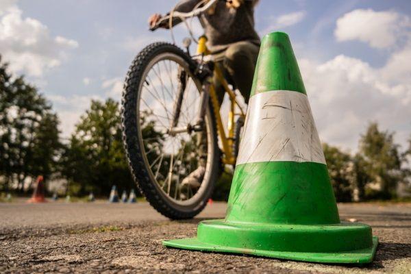 Fahrrad, das um einen Strassenkegel fährt