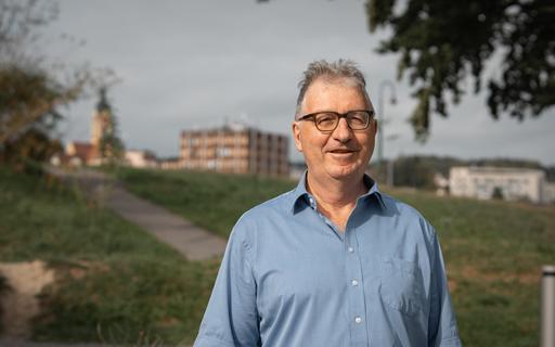 Ein Mann in Emmen vor Verwaltungsgebäude und Gerliswil-Kirche.