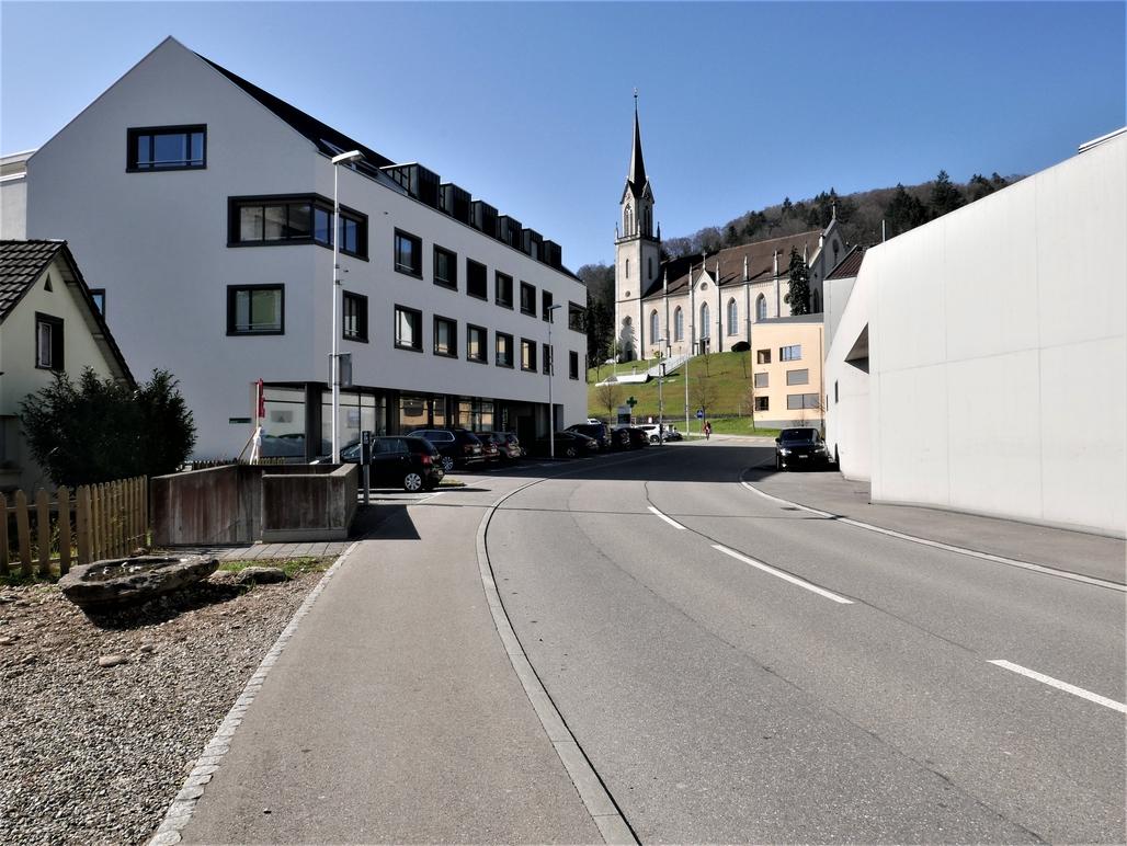 Die Alte Bahnhofstrasse im urbanen Dorfzentrum mit Blick auf die katholische Kirche.