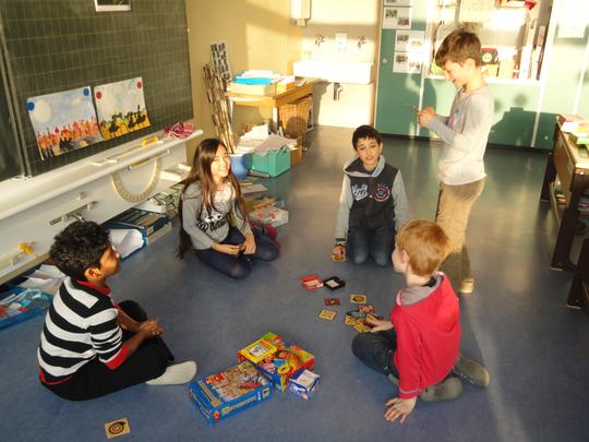Kinder mit Gesellschaftsspiel im Schulzimmer