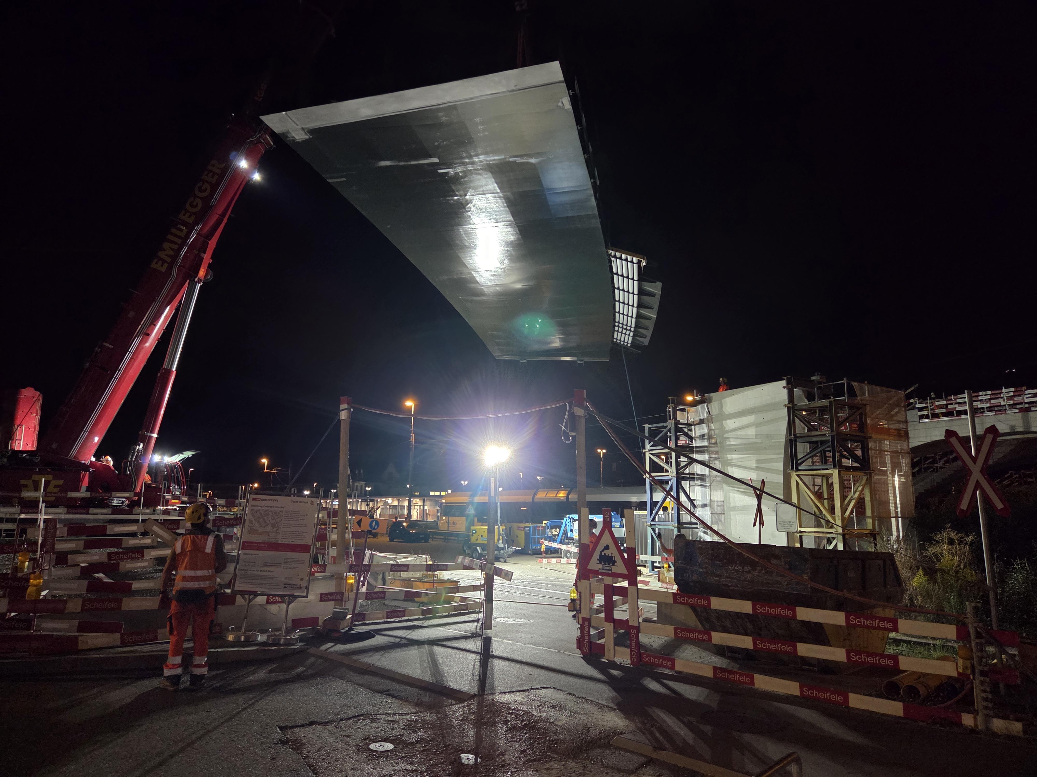 Das zweite Brückenteil wird montiert. Um den Betrieb am Bahnhof möglichst wenig zu stören, werden die kommenden Brückenelemente in der Nacht eingehoben.