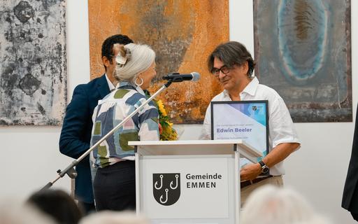 Ein Mann erhält auf Bühne eine Urkunde