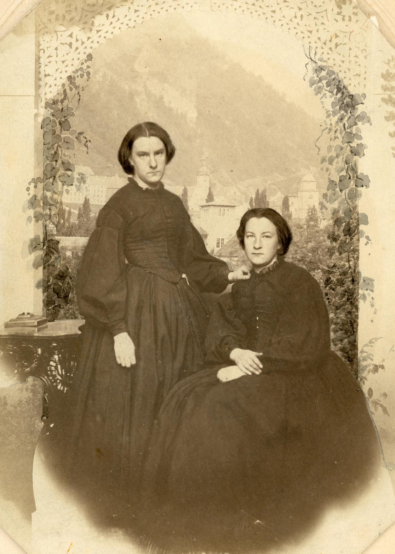 Raffinierte Fotomontage
auf Salzpapier. Porträtfoto von Marie Annette
(1839–1894) und Anna Augusta Caviezel
(1841–1903). Als Hintergrund dient eine der
ältesten fotografischen Abbildungen der
Stadt Chur. (StadtAC, N 237.0096, Foto
Israel Darms, ca. 1862–1864).