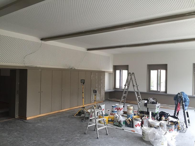 Die Akustik-Decke mit dem Tiefton-Asborber in der Seitenwand ist vom Gipser fertig montiert und verspachtelt. Der Maler ist an den Abschlussarbeiten für den Saal welcher künftig vom Musikverein und Männerchor als Proberaum genutzt wird.