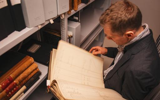 Mann blättert in historischem Dokument.