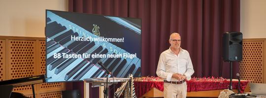 Der Musikschulleiter begrüsst die Gäste zur Auktion im Musikhaus.