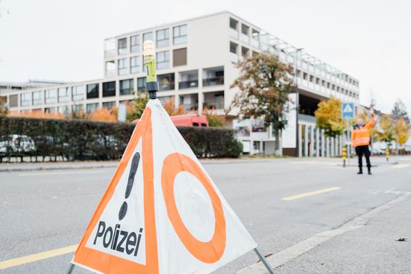 Polizist steht auf der Strasse und hält den Verkehr an