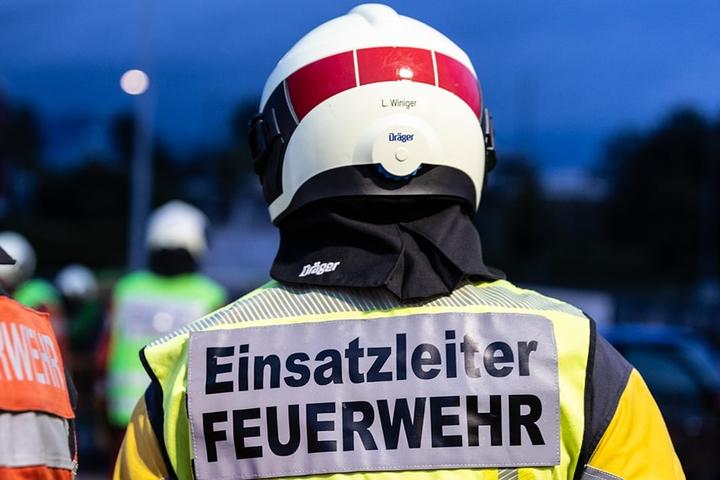Bild von zwei Feuerwehrleuten von hinten mit Beschriftung Einsatzleiter Feuerwehr