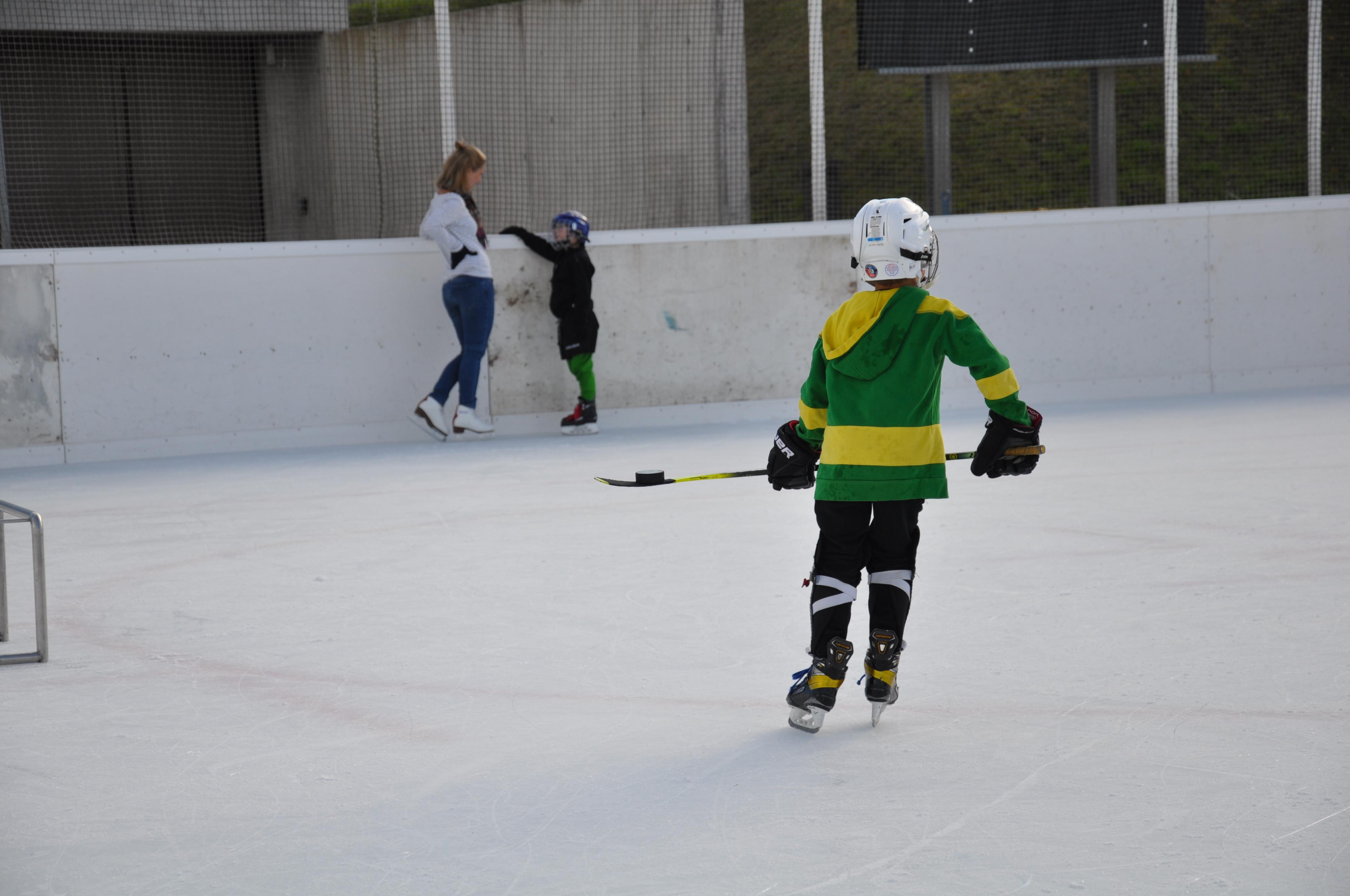 Junge mit Einhockeyschläger auf der Eisbahn Brand im November 2021
