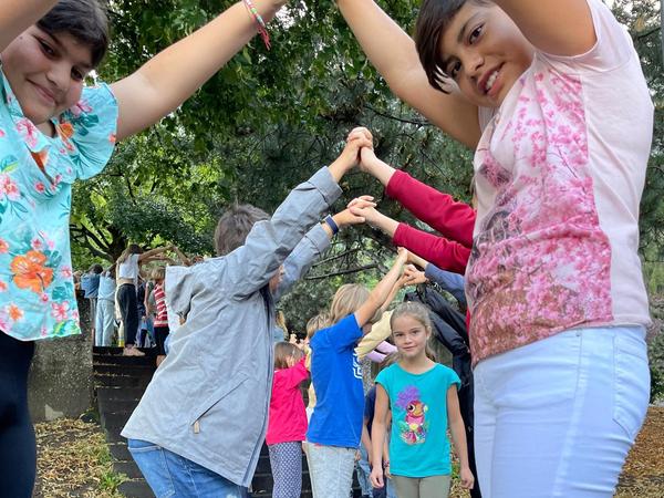Die Schülerinnen und Schüler machen für die neuen 1. KlässlerInnen einen Torbogen und heissen sie so herzlich im Montalin willkommen