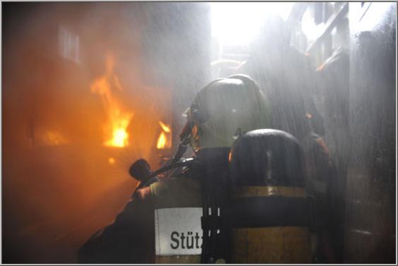 Atemschutztrupp mit Feuer im Hintergrund
