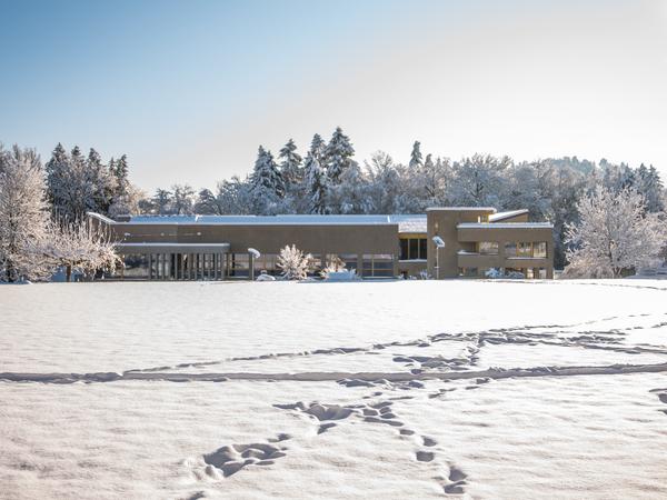 Das Schulhaus und der Sportplatz liegen unter einer weissen Schneedecke.