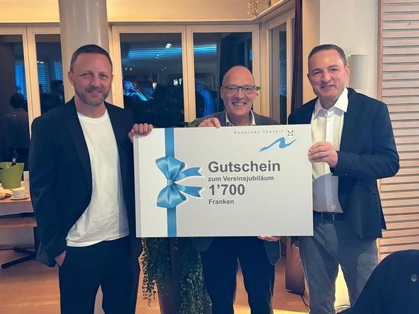 Drei Männer mit einem Gutschein in der Mitte