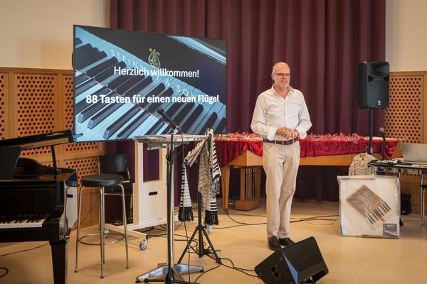 Der Musikschulleiter begrüsst die Gäste zur Auktion im Musikhaus.