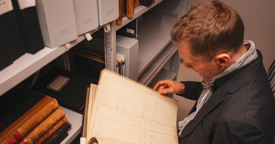 Mann blättert in historischem Dokument.