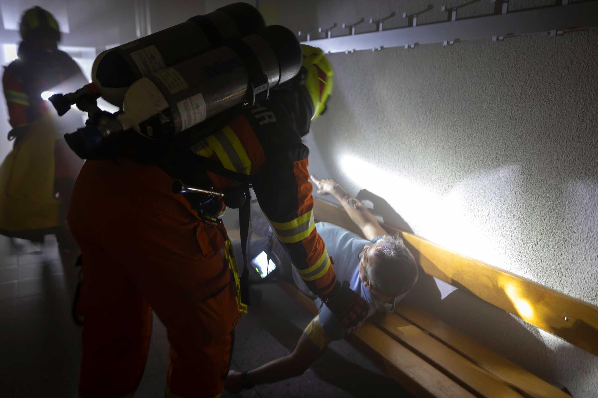 Feuerwehrleute stosen auf einen weiteren Figuranten, 