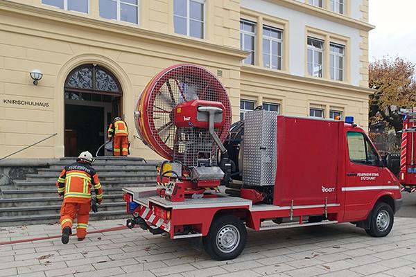 Im Knirischulhaus bricht in einem WC Feuer aus. Die Feuerwehr löscht den Brand und belüftet das Gebäude, während die Schulkinder in der nahen Klosterkirche in Sicherheit warten.