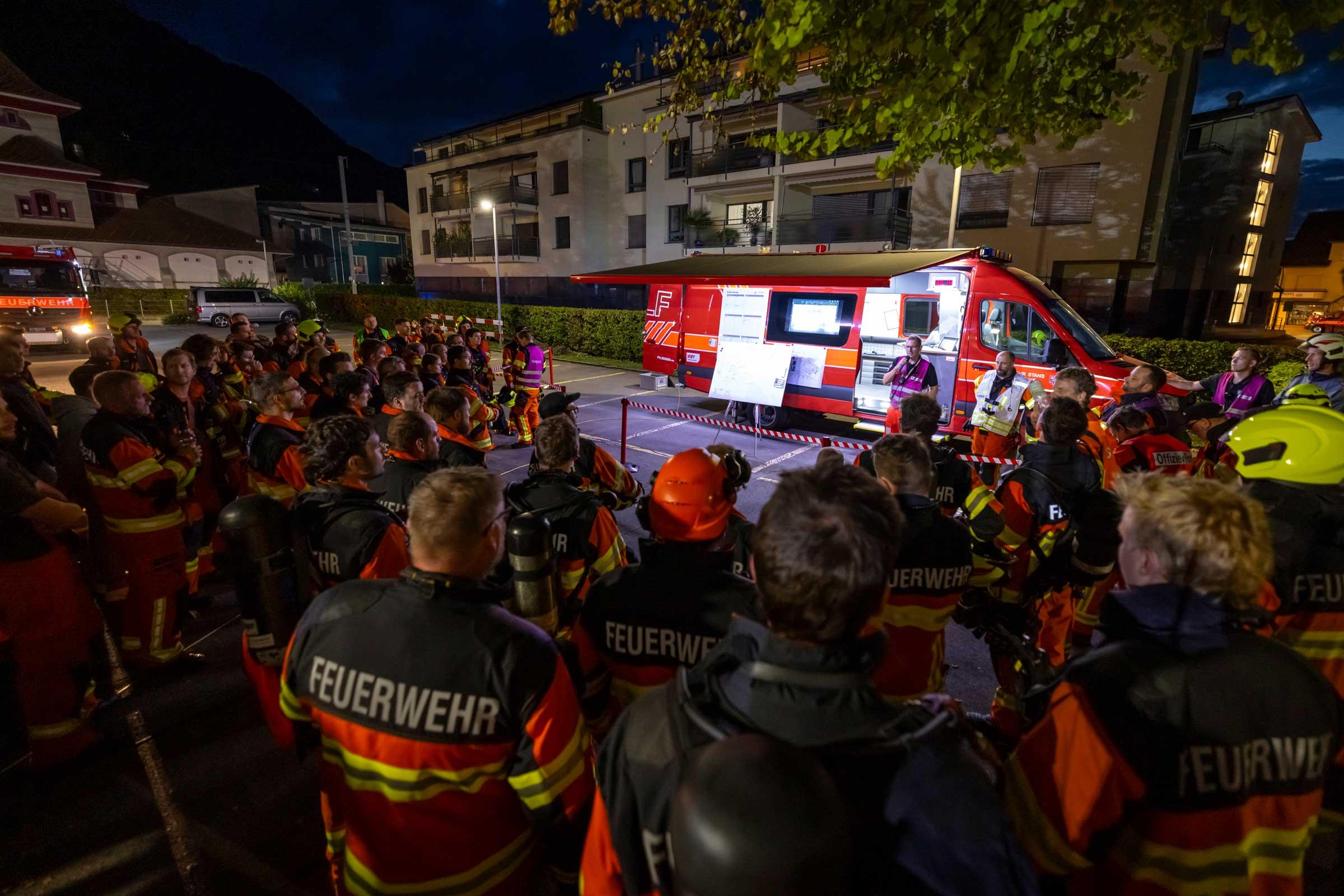 Die Einsatzkräfte versammeln sich beim Einsatzleitfahrzeug.