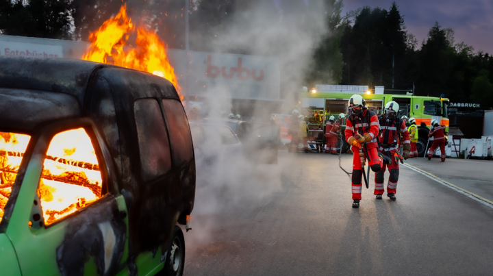 Bild einer Feuerwehrübung mit einem brennenden Auto