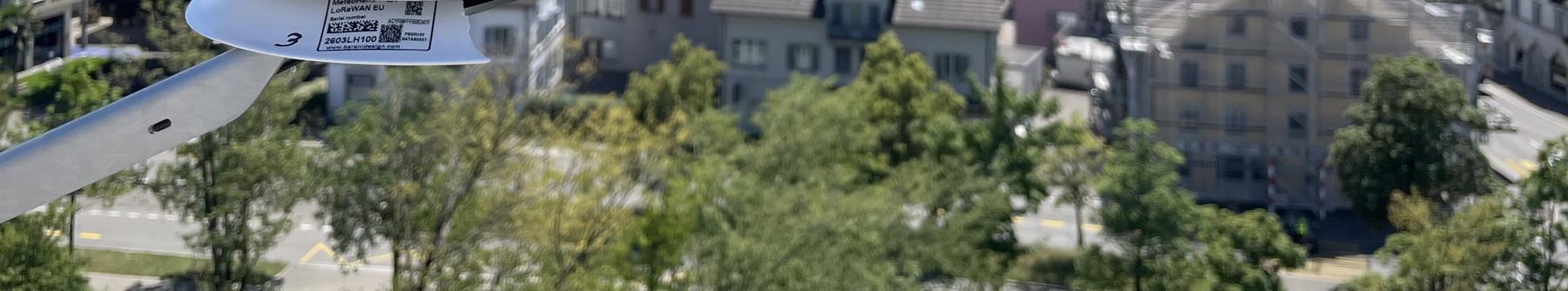 Blick über Uster mit der Kirche und Burg im Hintergrund und einem Klimasensor im Vordergrund