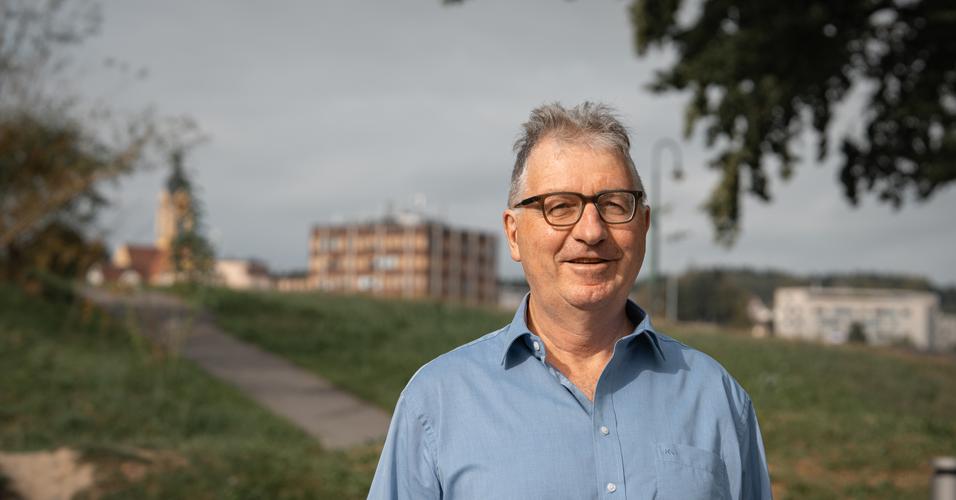 Ein Mann in Emmen vor Verwaltungsgebäude und Gerliswil-Kirche.