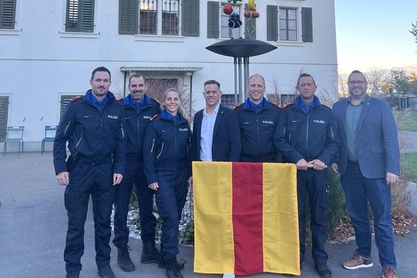 Das Gemeindehaus Richterswils ist im Hintergrund zu sehen, während im Vordergrund das Team der Gemeindepolizei zu sehen ist (5 Personen) mit Gemeindepräsident Marcel Tanner und Gemeinderat Renato Pfeffer