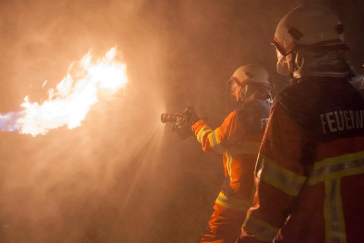 Wie bereits zuvor der Einsatzzug 2 übt der Einsatzzug 1 den Löschdienst. Dabei kommen realistische Simulationsmittel zum Einsatz. An der Gasflamme erproben die Feuerwehrleute die Kühlwirkung des Wasser-Sprühstrahls.