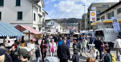 Zu sehen sind Schaulustige, die durch die Untere Bahnhofstrasse an den Marktständen vorbeischländern.
